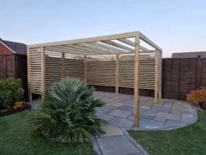 Finished garden area in Stowupland featuring sandstone patio and bespoke wooden pergola.